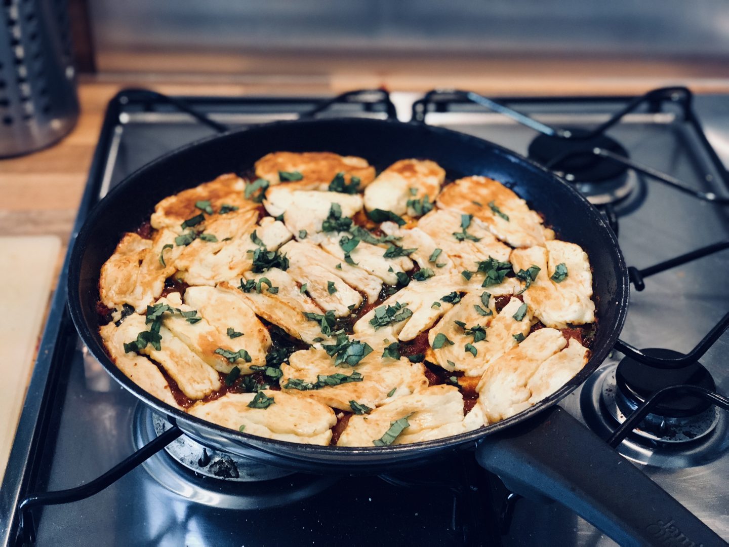 halloumi hash in a frying pan with basil on top