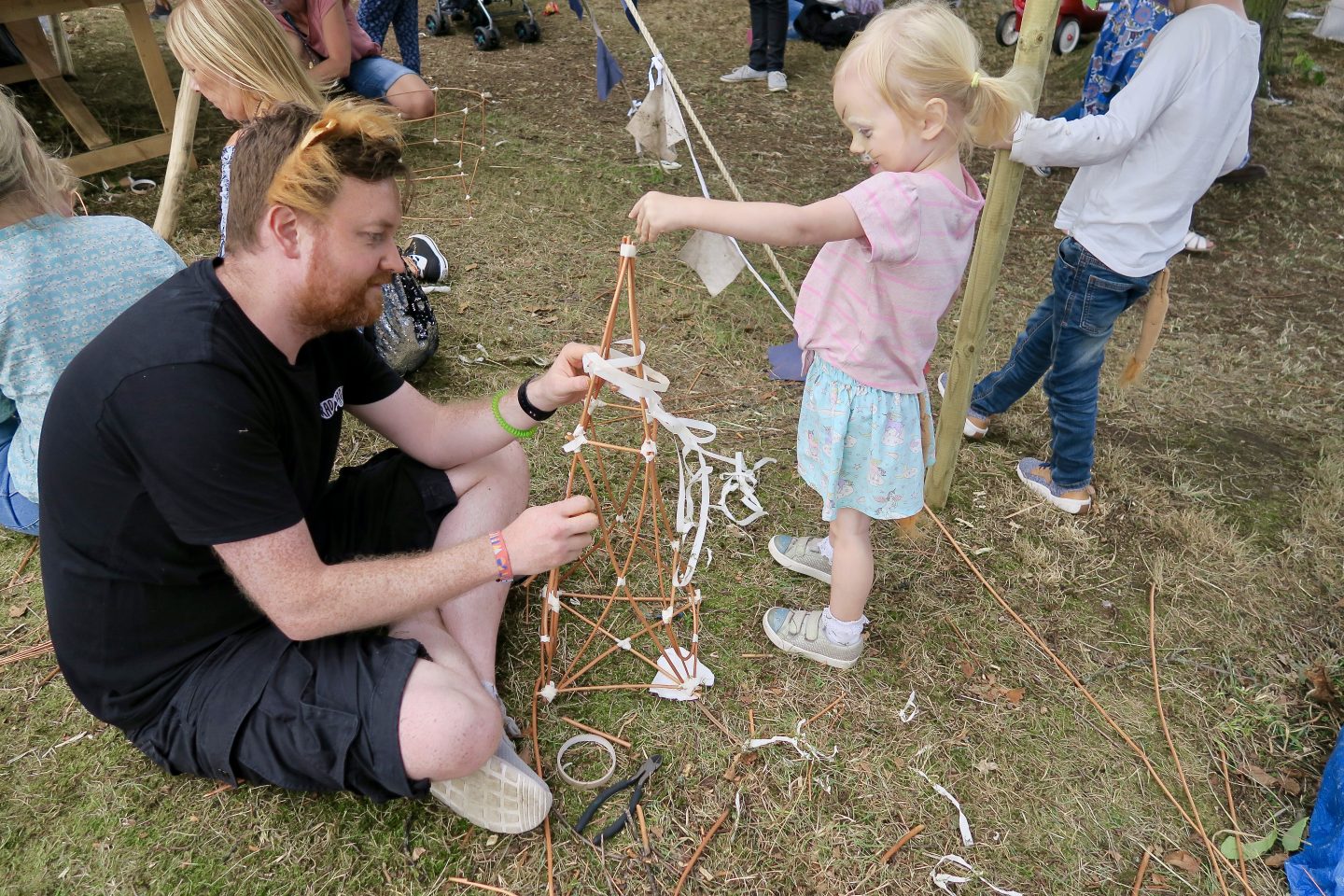 Man and girl make a paper latern at a festival 