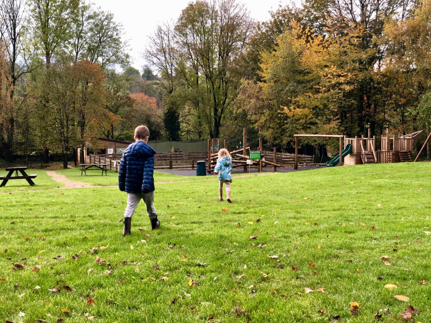 AD: Landal Sandybrook Peak District family review - a relaxing autumnal long weekend break. Kids running towards the playground at Landal Sandybrook.
