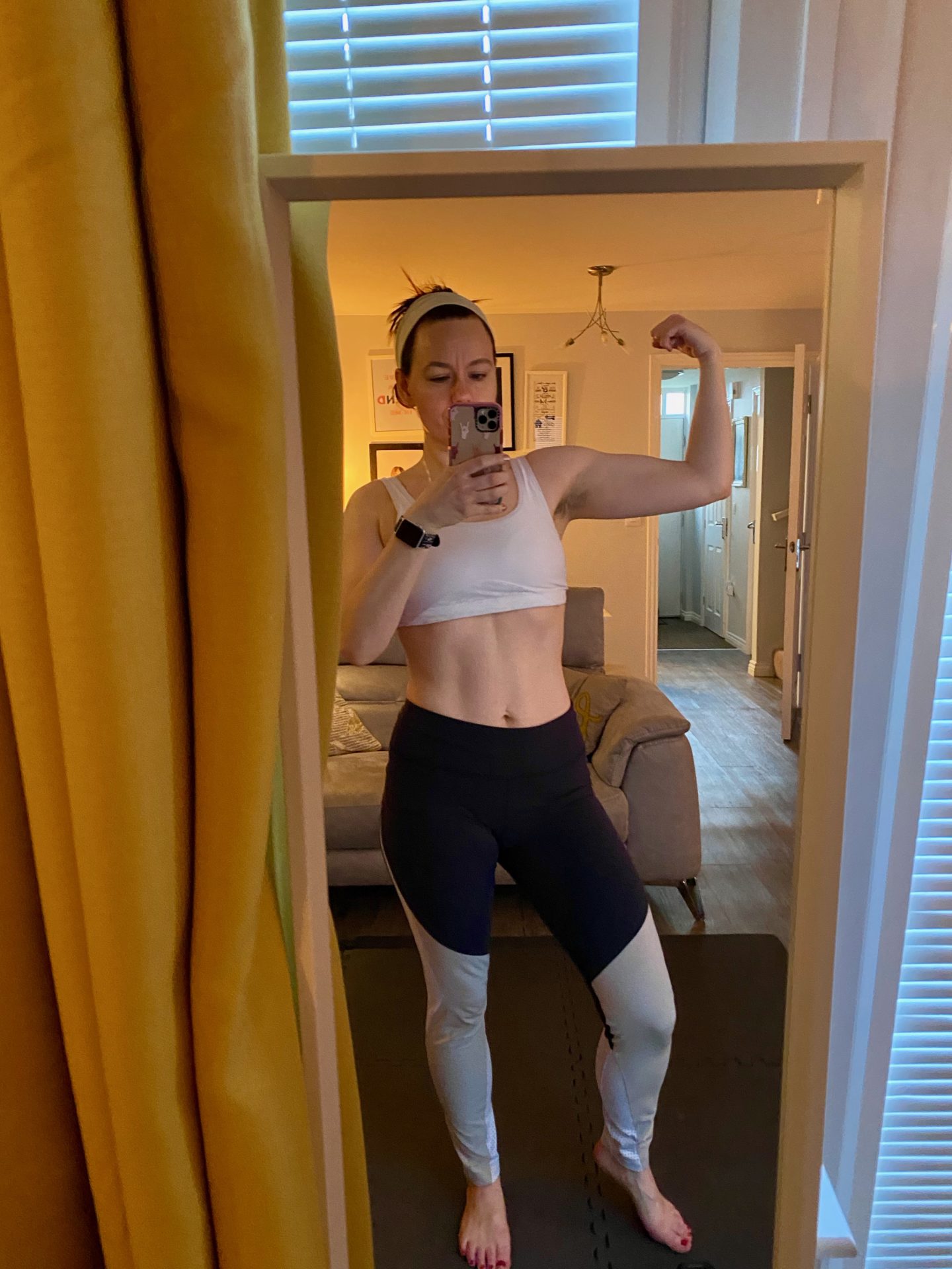 Woman flexes her bicep in a mirror selfie