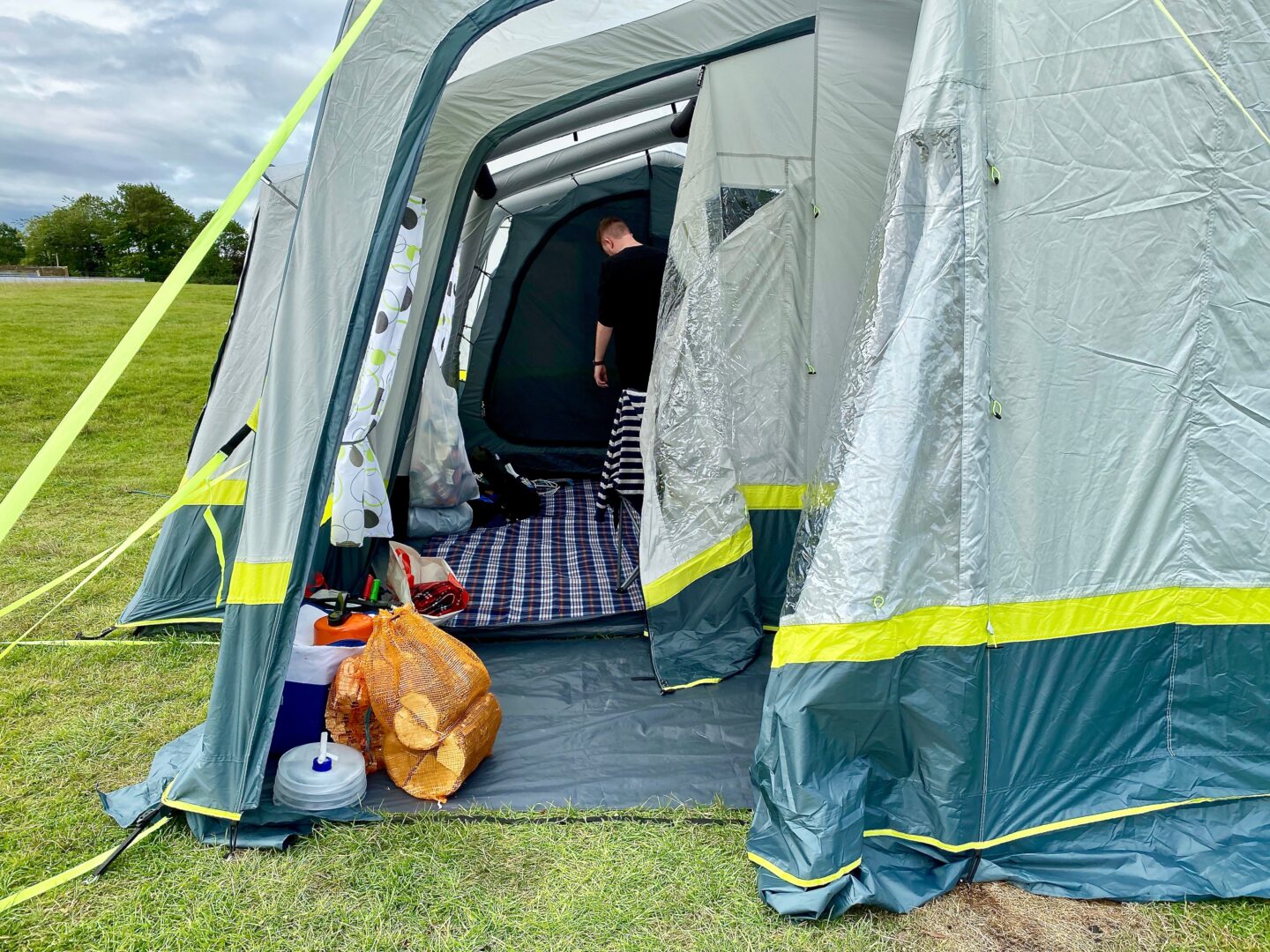 The porch of the OLPRO home tent - you can see that it's spacious and that it is storing some water and a bag of logs for the fire