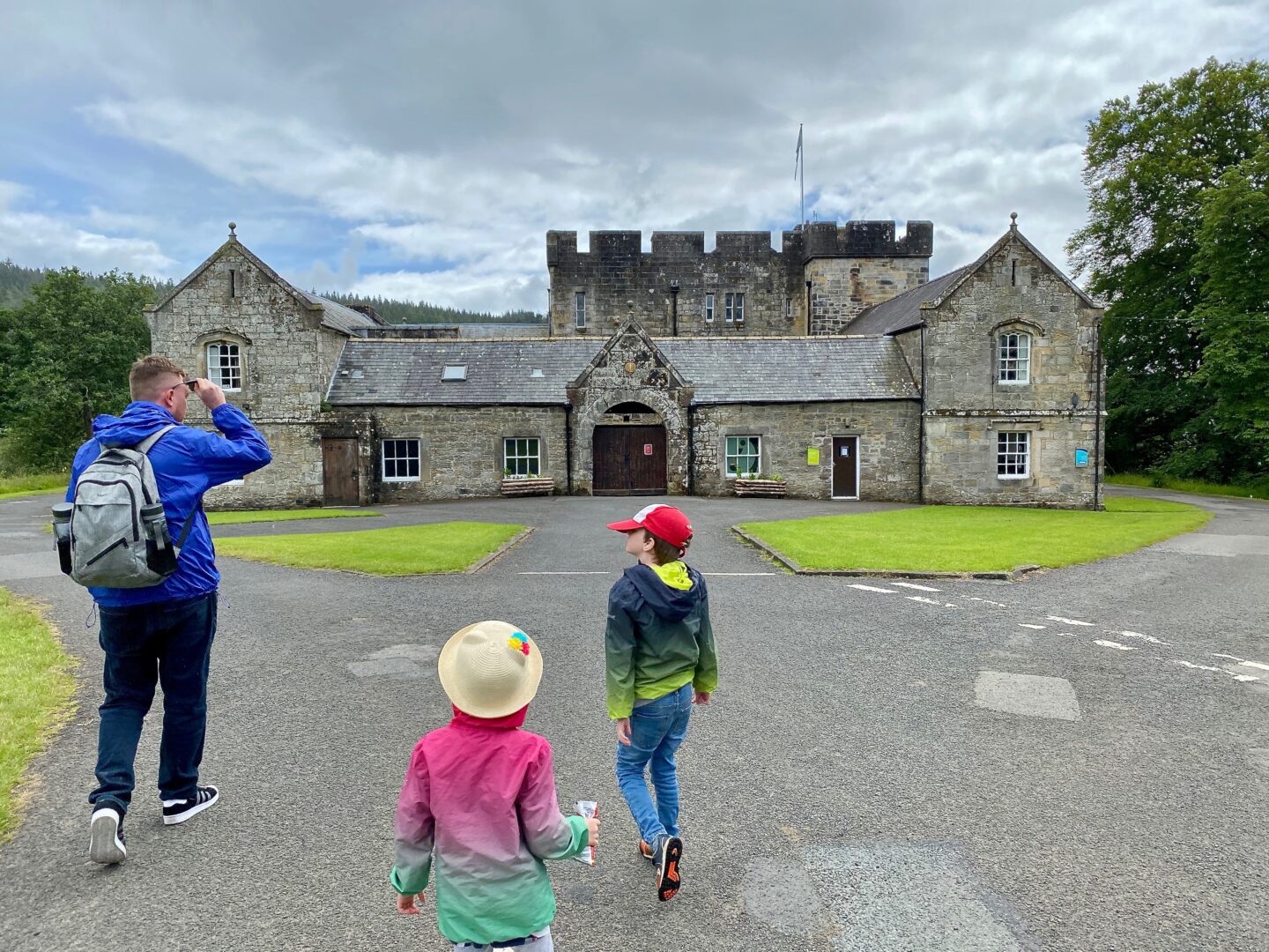 A picture of Kielder castle with a man and 2 children