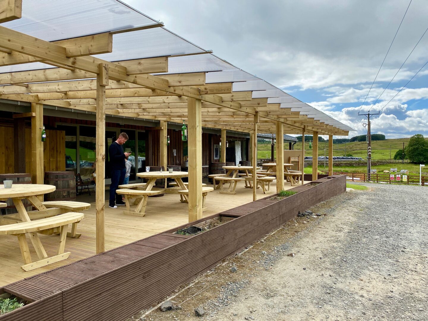 Outdoor seating at the Boe Rigg restaurant - 4 picnic tables under a pergola 