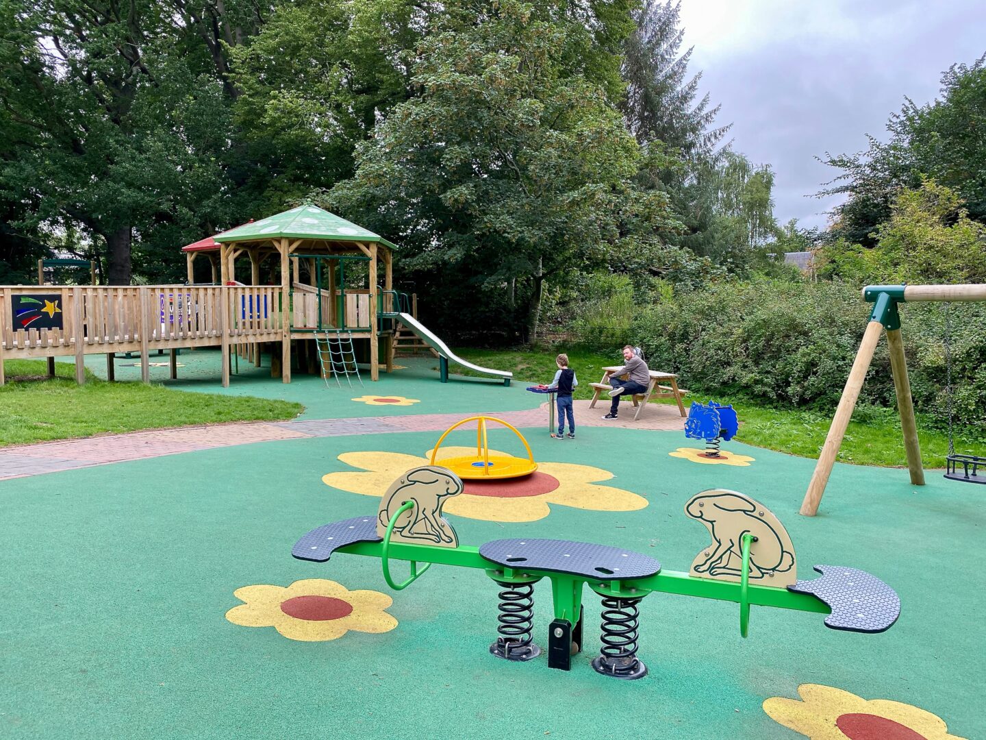 A play park showing a slide, climbing apparatus and a see saw