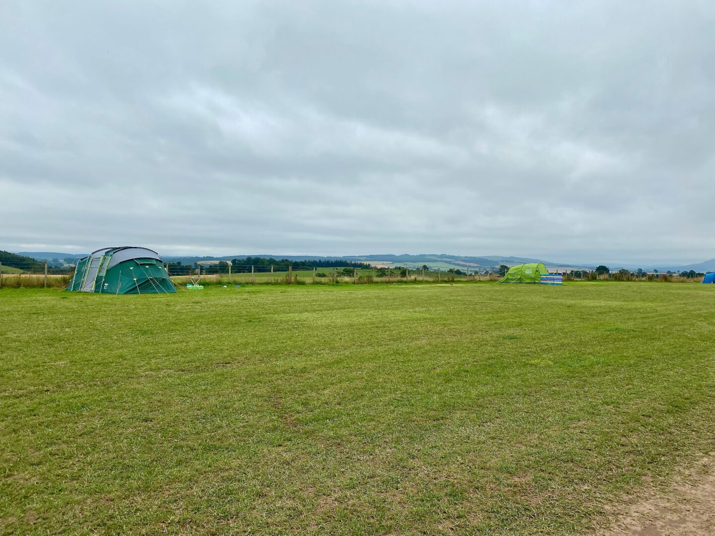 A campsite next to the hills containing two tents 