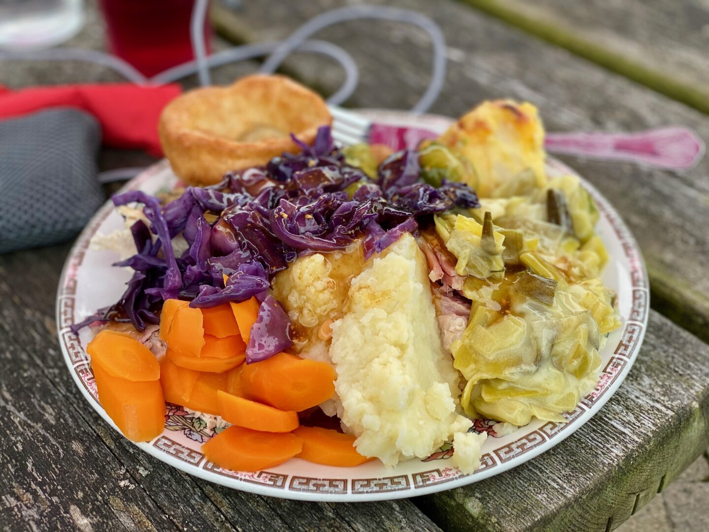 A plate filled high from a carvery with carrots, mash, red cabbage, creamed leeks, gammon, cauliflower cheese and a yorkshire pudding.