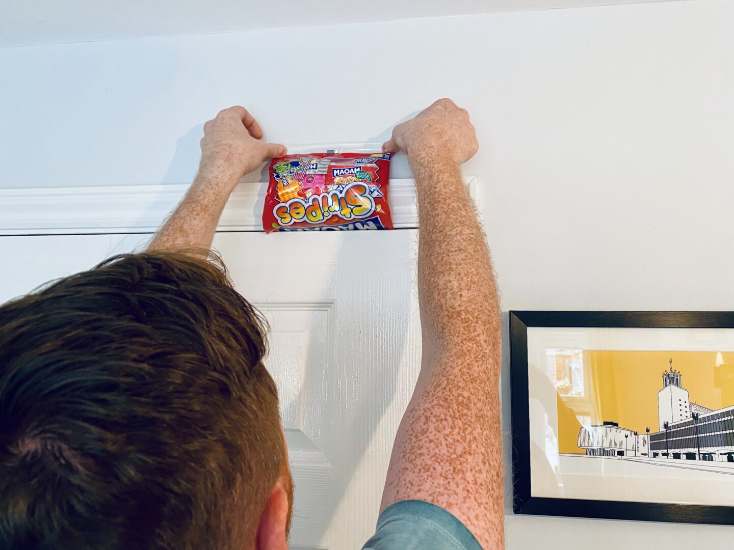 A man putting Maoam sweets into a door for a prank