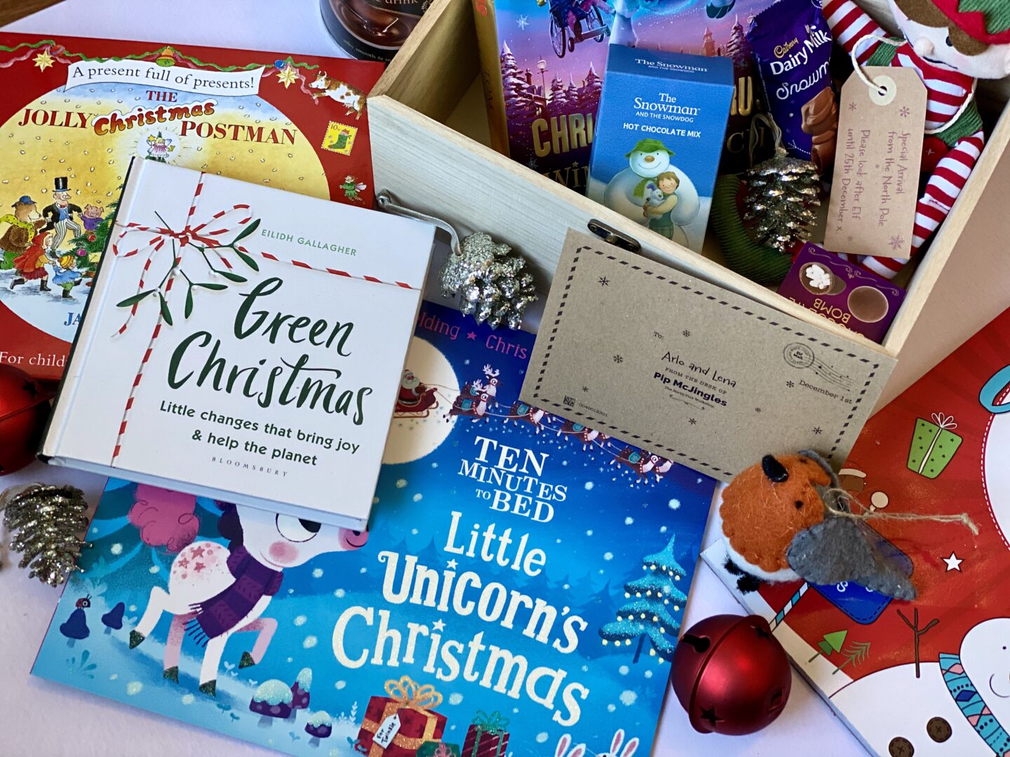 A box full of Christmas items like hot chocolate, books and an elf