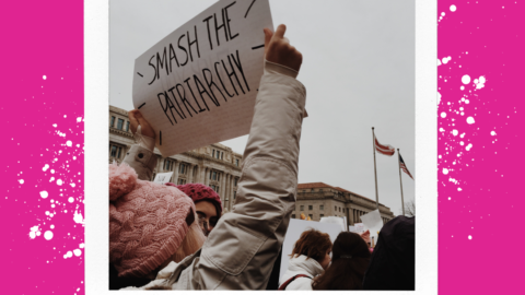 A woman at a rally holding up a smash the patriarchy sign