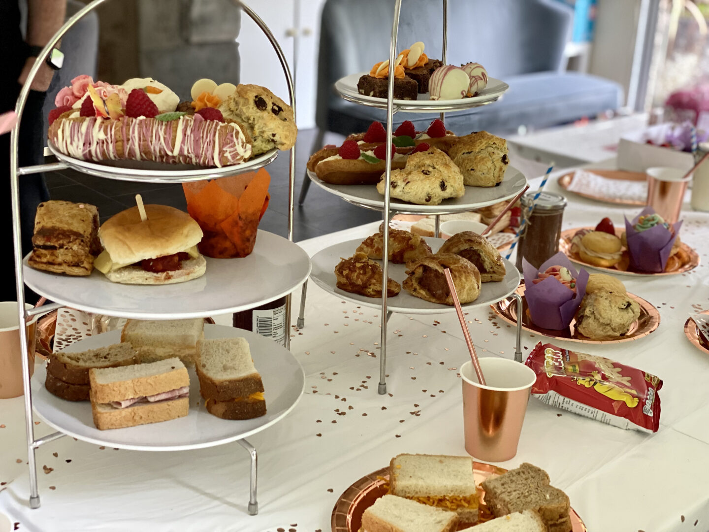 An afternoon tea set out on a dining table on cake stands