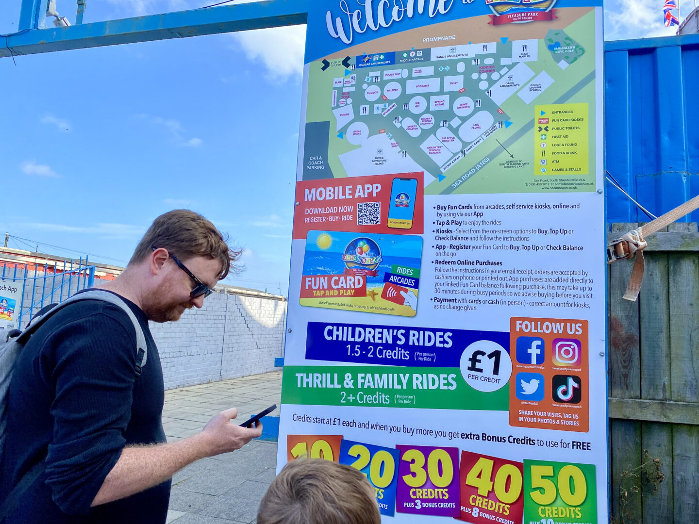 A family look at a sign at Ocean Pleasure Beach