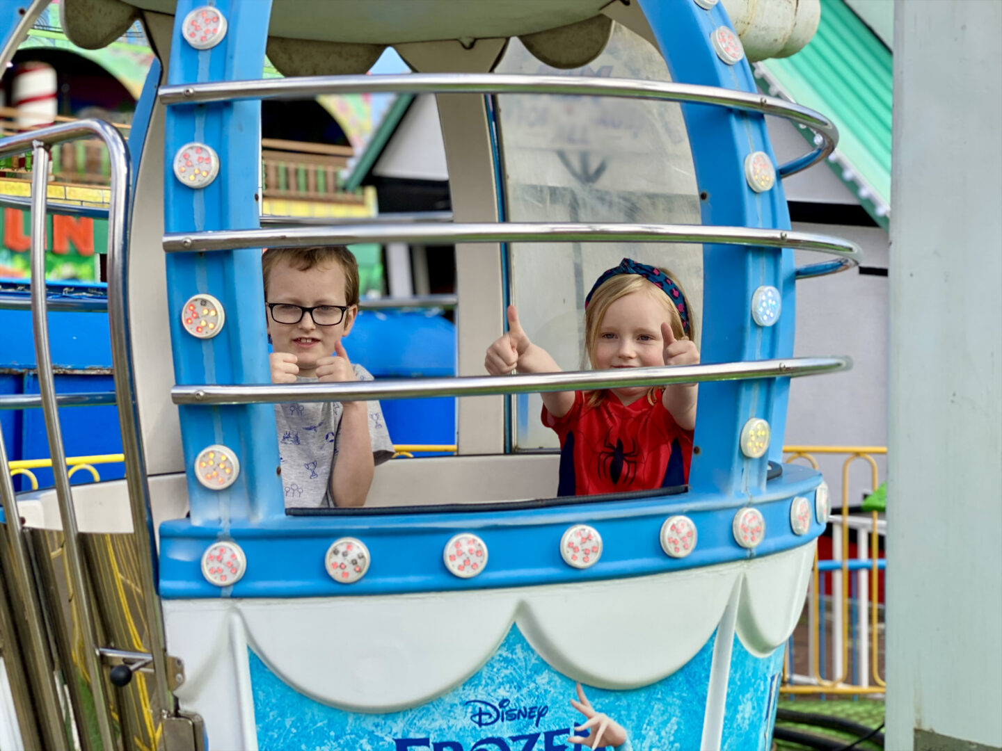 a boy and girl smiling on a ferris wheel ride