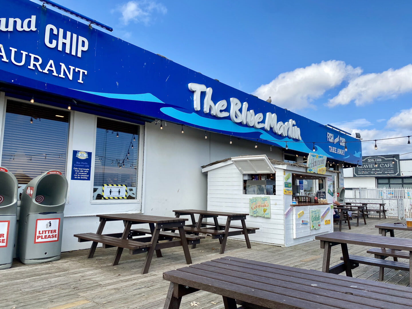 The outdoor eating area of the Blue Marlin with a tiki bar and picnic tables