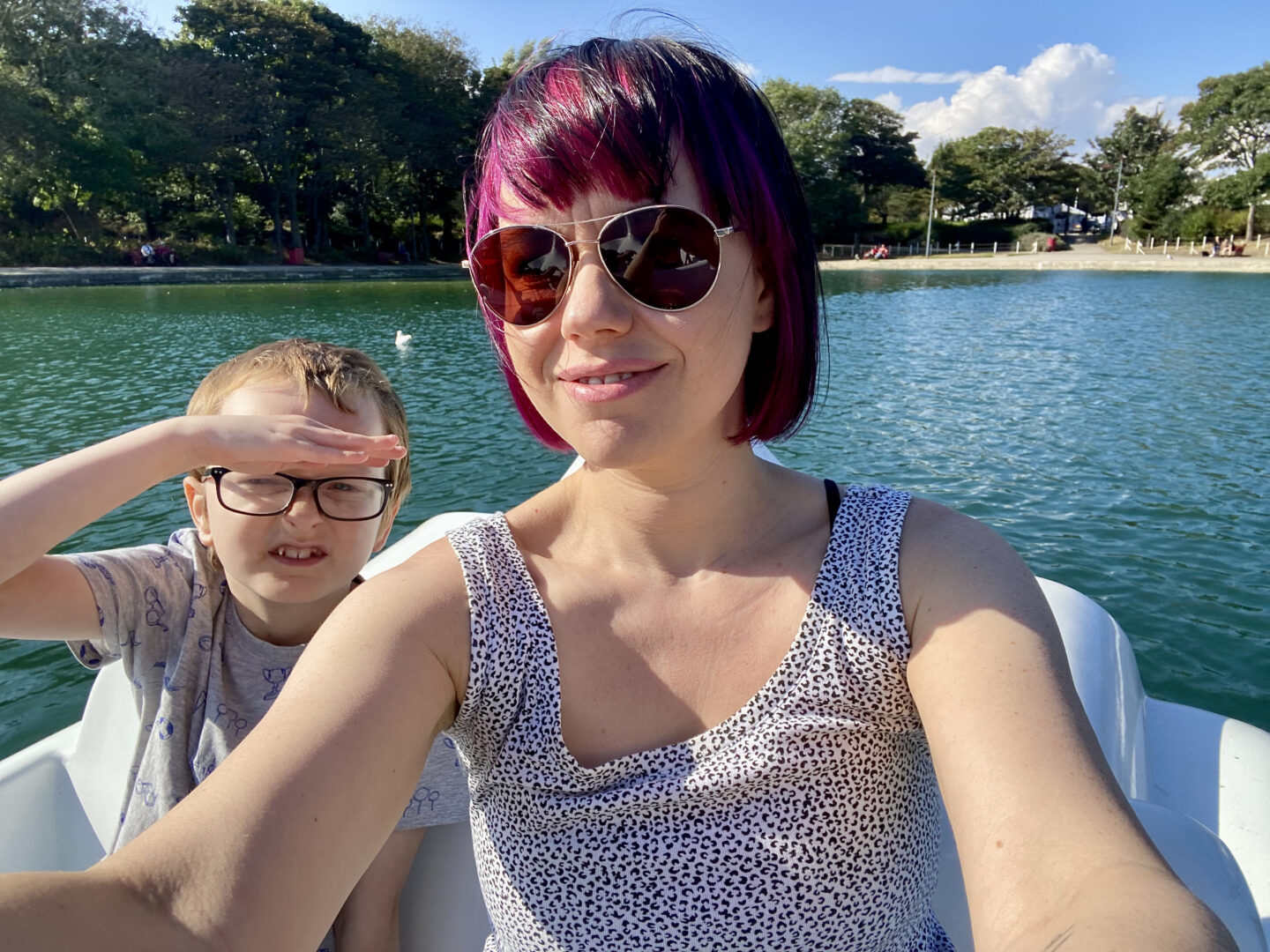 a woman and 9 year old boy on a boat in a boating lake