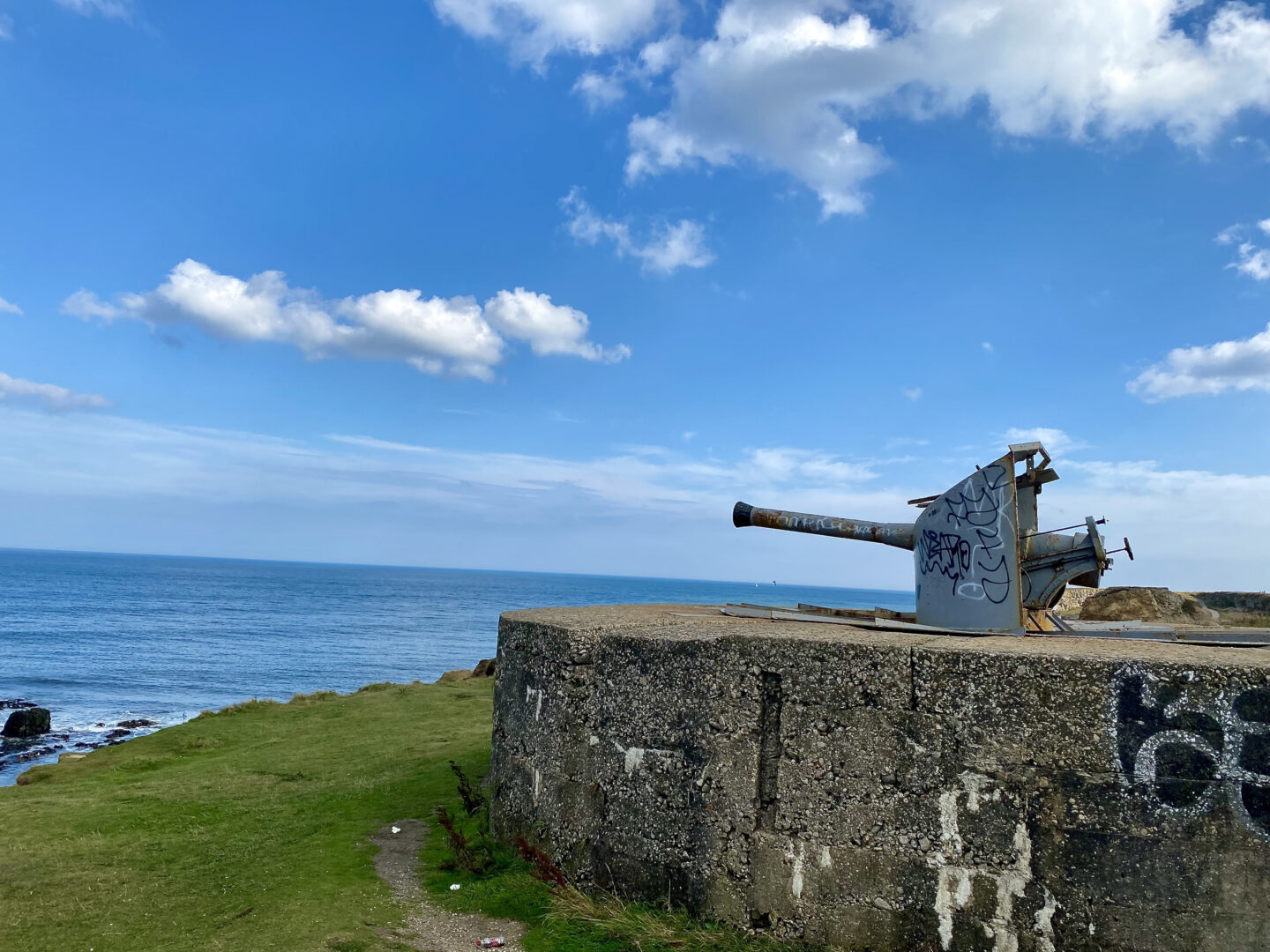 A large grade 2 listed military gun stands on a cliff top