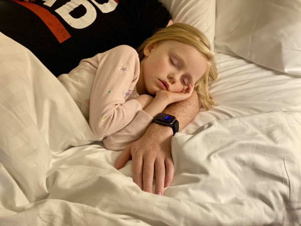 Little blonde girl asleep on her dad's arm