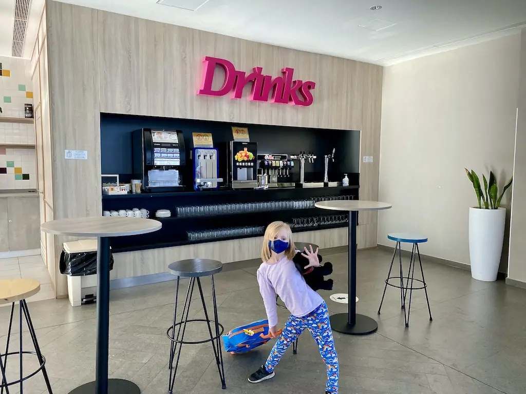 Self service drinks station with a little girl in front of it