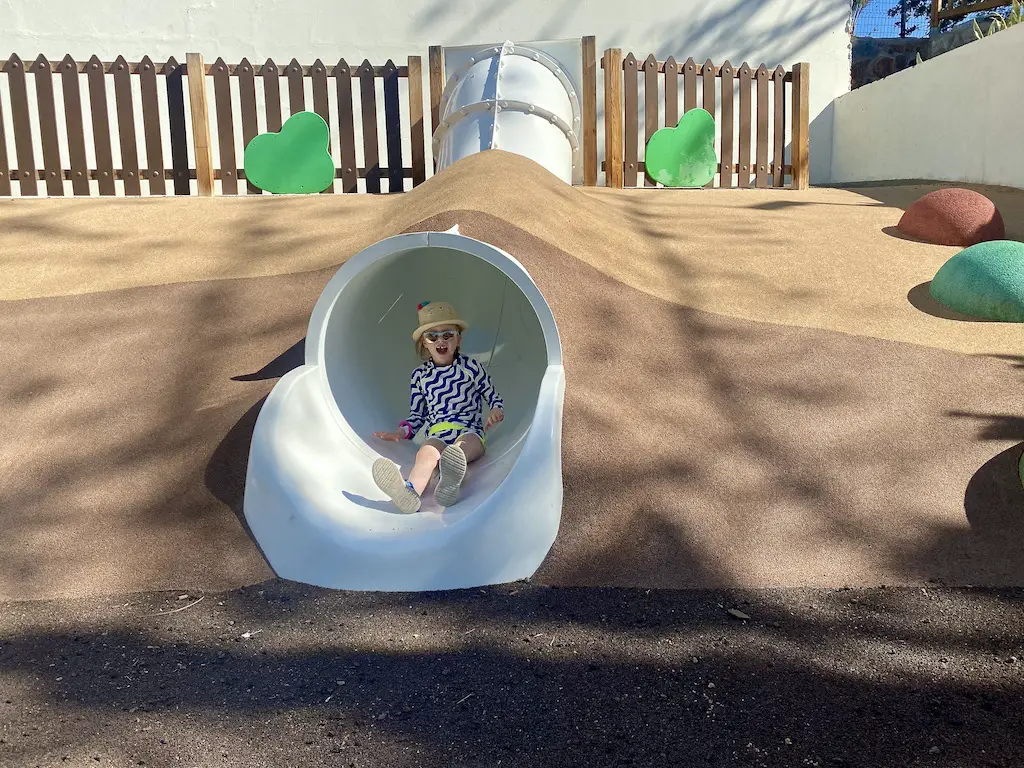 Little girl at the bottom of a slide 