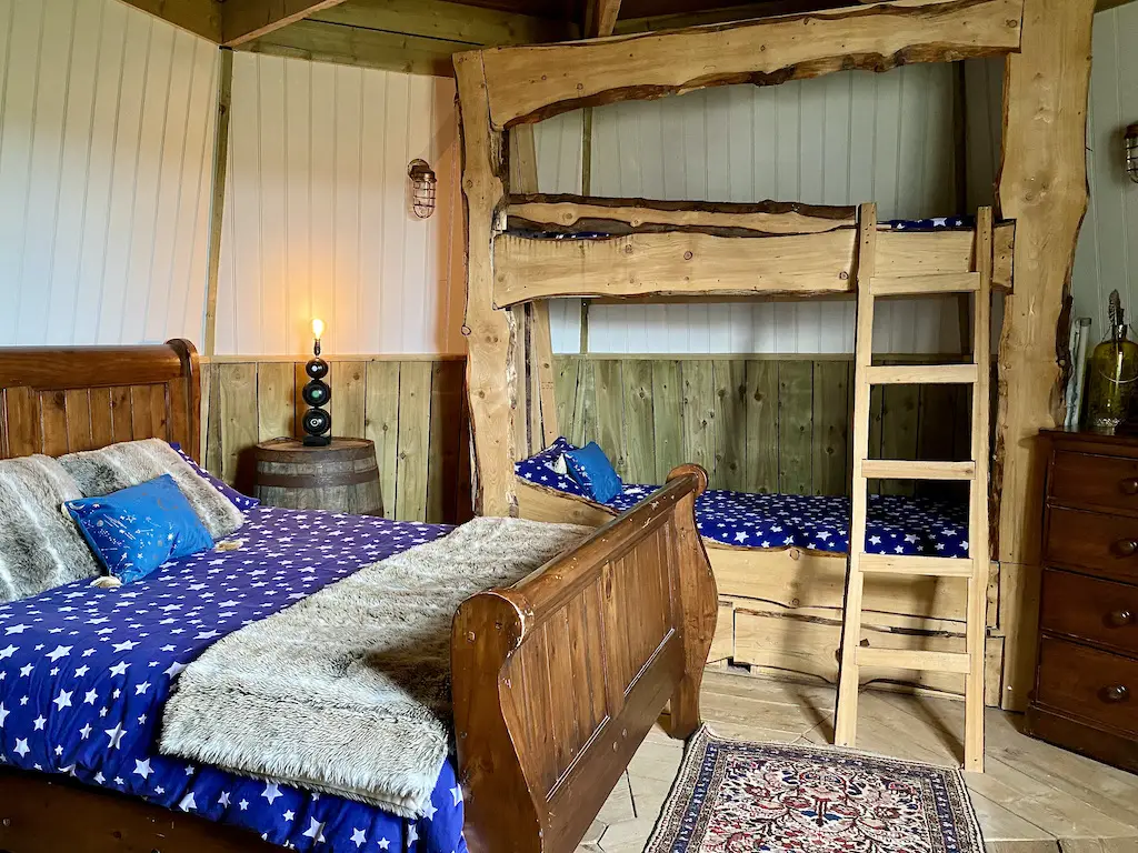 A wooden double bed and bunkbed of a rustic but modern style