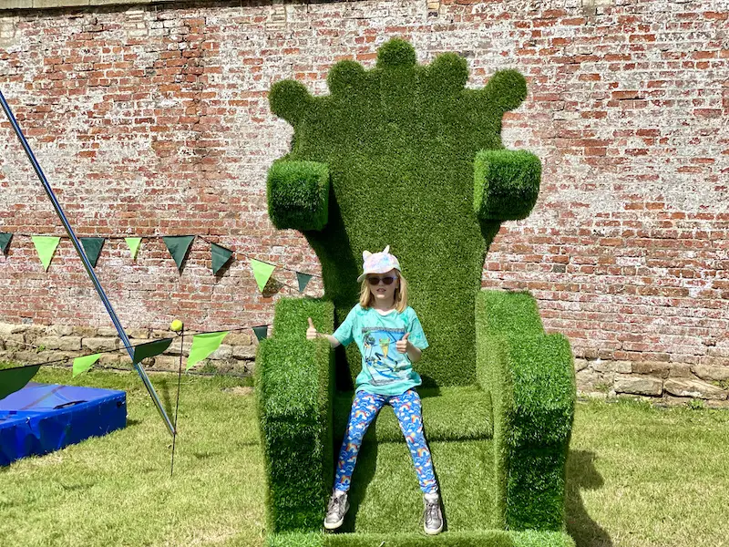 A blonde girl sits on a giant grass chair at Little Lindi Festival. 