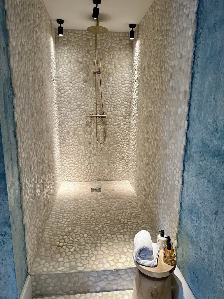 A large show with small stone tiles at Runa Farm's Courtyard Suite