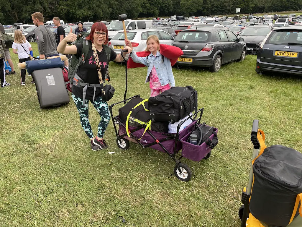 A woman and child with their belongings queuing to go inside Y Not music festival - biggest UK festivals. 