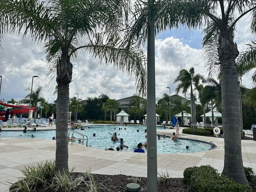 Encore resort pools - palm trees and a busy curved pool with cloudy skies 