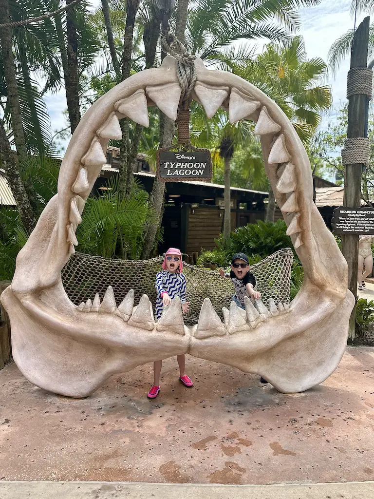 2 children stood in a giant fake shark mouth at Disney World's Typhoon Lagoon