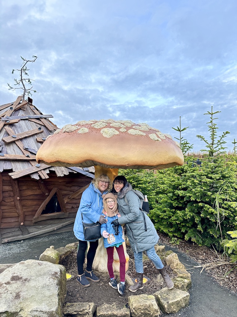 A damily getting a photo under a giant mushroom at Lilidorei