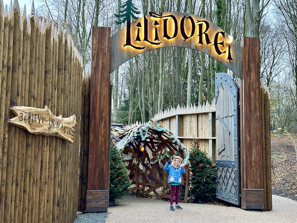 Christmas at Lilidorei - wooden wall and glowing Lilidorei sign in front of a tunnel
